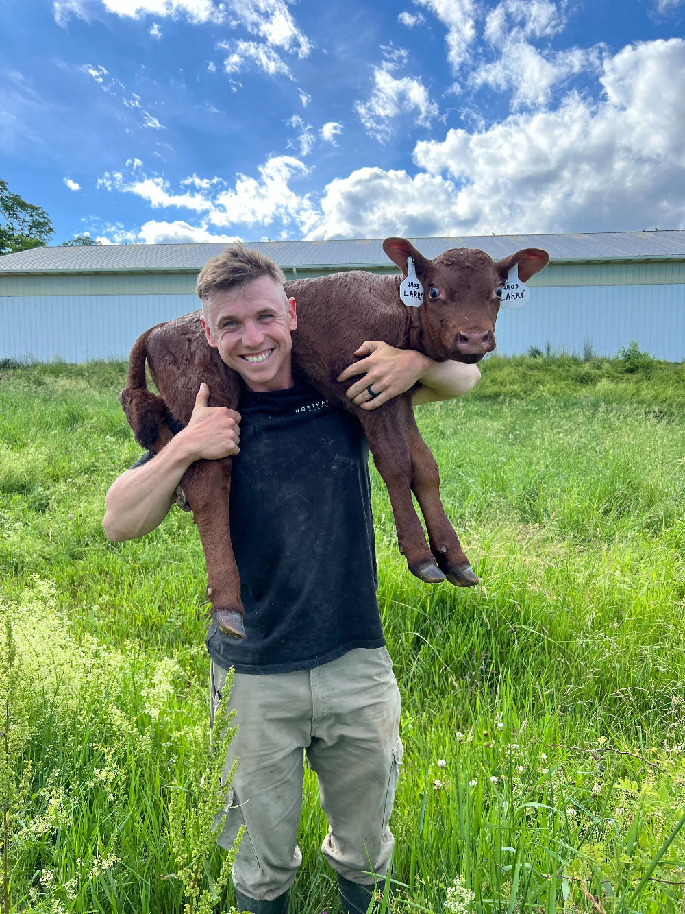 Farmer Bennett holding baby calf Larry